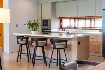 a kitchen with a island with four bar stools at Botanica Foresta - 4 Bedroom Spacious Luxury Pool Villa in Layan in Ban Phru Champa