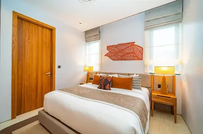 a bedroom with a large bed and two windows at Botanica Foresta - 4 Bedroom Spacious Luxury Pool Villa in Layan in Ban Phru Champa