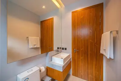a bathroom with a sink and a toilet and a mirror at Botanica Foresta - 4 Bedroom Spacious Luxury Pool Villa in Layan in Ban Phru Champa