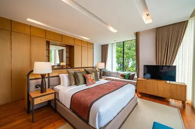 a bedroom with a large bed and a television at Botanica Foresta - 4 Bedroom Spacious Luxury Pool Villa in Layan in Ban Phru Champa