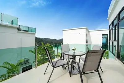 a patio with a table and chairs on a balcony at Namara The Residences A in Kamala Beach