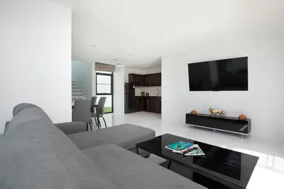 a living room with a gray couch and a flat screen tv at Namara The Residences A in Kamala Beach