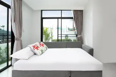a bed in a room with a large window at Namara The Residences A in Kamala Beach