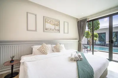 a bedroom with a white bed and a pool at Tropical 4 Bedroom Pool Villa in Laguna Phuket