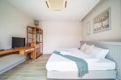 a bedroom with a white bed and a television at Tropical 4 Bedroom Pool Villa in Laguna Phuket