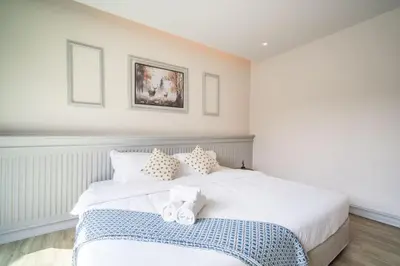 a bedroom with a white bed with two towels on it at Tropical 4 Bedroom Pool Villa in Laguna Phuket