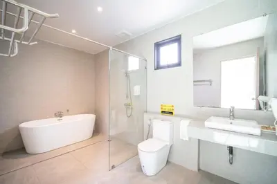 a bathroom with a tub and a toilet and a sink at Tropical 4 Bedroom Pool Villa in Laguna Phuket