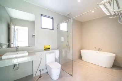 a bathroom with a tub and a toilet and a sink at Tropical 4 Bedroom Pool Villa in Laguna Phuket