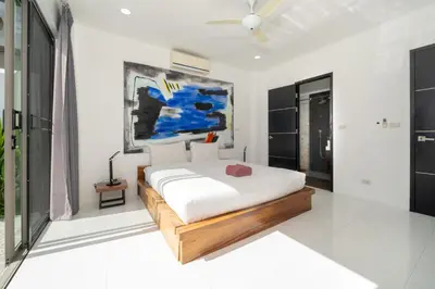 a bedroom with a bed and a painting on the wall at Spacious 4BR Private Pool Villa Luna in Rawai Beach