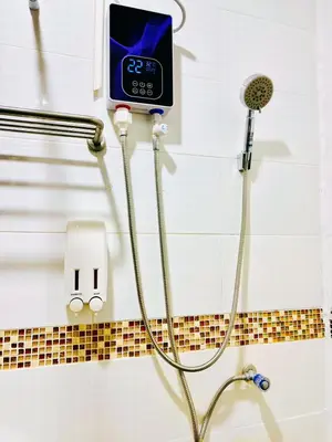 a shower with a digital clock on the wall at TJ Patong HOSTEL in Patong Beach