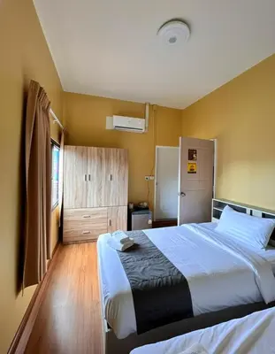 a bedroom with a large bed and a refrigerator at I Talay phuket in Karon Beach