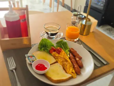 a plate of breakfast food with eggs sausage and toast at I Talay phuket in Karon Beach