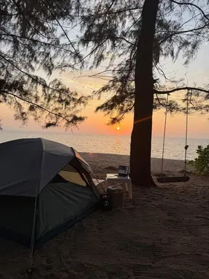 a tent on the beach with a tree and a table at TENT Maikhao in Ban Mai Salae