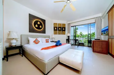 a bedroom with a large white bed and a balcony at Allamanda Premium Apartments Laguna Phuket in Laguna Phuket