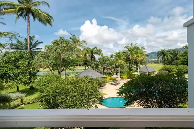 a view of a resort with a swimming pool and palm trees at Allamanda Premium Apartments Laguna Phuket in Laguna Phuket