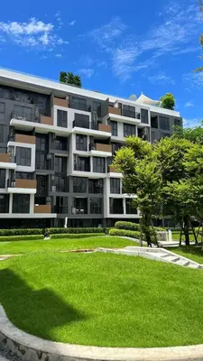 a large apartment building with a green lawn in front of it at Sky Park Laguna Phuket in Laguna Phuket