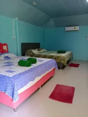 two beds in a room with blue walls and red rugs at Phukhao thong in Ban Bang Chak