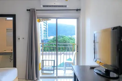 a living room with a television and a balcony at Stay at Bedroom in Patong Beach