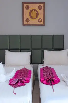 two beds with pink sheets sitting next to each other at Stay at Bedroom in Patong Beach