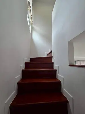 a stairway with brown steps and a mirror at MB Home in Ban Bang Khu