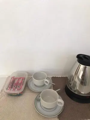 two coffee cups on plates next to a tea kettle at maksaihomestay in Ban Lo Pa Ret