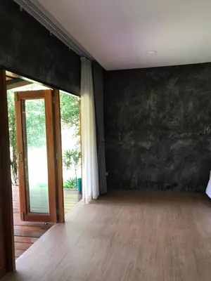 an empty room with a wooden floor and a sliding glass door at maksaihomestay in Ban Lo Pa Ret