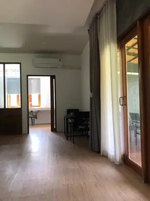 a living room with a wooden floor and sliding glass doors at maksaihomestay in Ban Lo Pa Ret