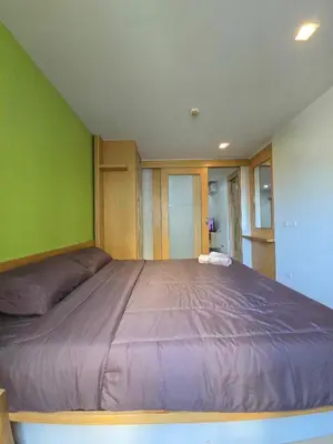 a large bed in a room with a green wall at The Feeltrue phuket ck in Ban Klang