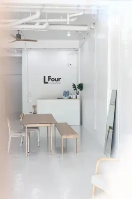 a table and chairs in a white room with a sign at Lfour phuket in Phuket Town