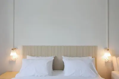a white bed with two white pillows and two lights at Lfour phuket in Phuket Town