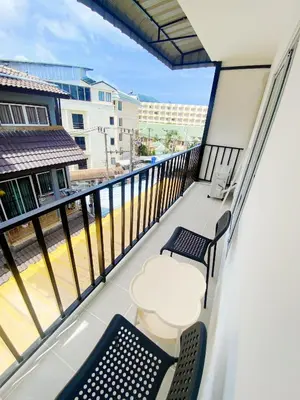 a balcony with two chairs and a table and chairs at SJ Beach House Patong in Patong Beach