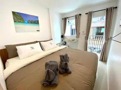 a bedroom with a bed with shoes on it at SJ Beach House Patong in Patong Beach