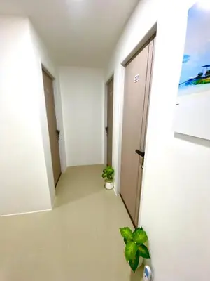 a hallway with a door and two plants at SJ Beach House Patong in Patong Beach