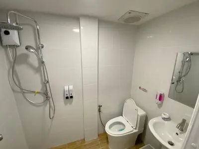 a bathroom with a shower and a toilet and a sink at SJ Beach House Patong in Patong Beach