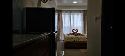a kitchen with a room with a bed with a window at Уютная квартира рядом с пляжем Май Као in Ban Mai Salae