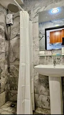 a bathroom with a shower curtain and a sink at Уютная квартира рядом с пляжем Май Као in Ban Mai Salae