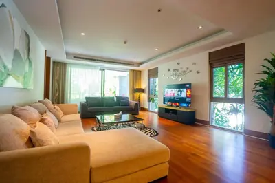 a living room with a couch and a tv at Suite of Naithon beachfront apartment in Nai Thon Beach