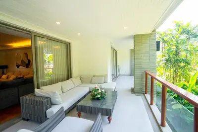 a living room with a couch and a table at Suite of Naithon beachfront apartment in Nai Thon Beach
