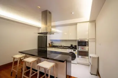a kitchen with a black counter top and white appliances at Suite of Naithon beachfront apartment in Nai Thon Beach