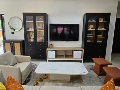 a living room with a couch and a tv at Eden Villas Kamala in Kamala Beach