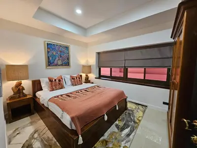 a bedroom with a large bed and a window at Eden Villas Kamala in Kamala Beach