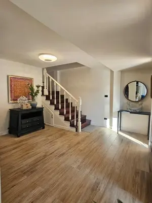 a living room with a staircase and a mirror at Eden Villas Kamala in Kamala Beach