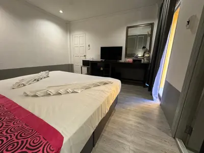 a bedroom with a bed and a desk and a mirror at At bedroom in Patong Beach