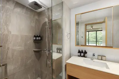 a bathroom with a shower and a sink and a mirror at Laguna beachside residences by My home Phuket in Bang Tao Beach