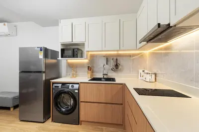 a kitchen with a washing machine and a refrigerator at Laguna beachside residences by My home Phuket in Bang Tao Beach