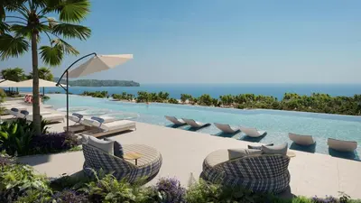 a pool at a resort with lounge chairs and the ocean at Laguna beachside residences by My home Phuket in Bang Tao Beach