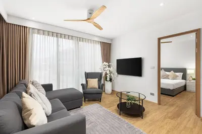 a living room with a couch and a tv and a bed at Laguna beachside residences by My home Phuket in Bang Tao Beach