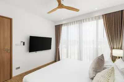 a bedroom with a bed and a tv on a wall at Laguna beachside residences by My home Phuket in Bang Tao Beach