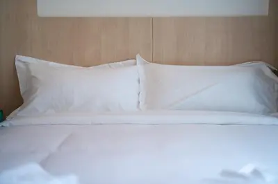 a bed with white sheets and pillows at Japanese-Style Condo close Kamala Beach in Kamala Beach