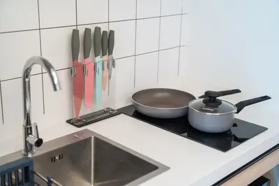 a kitchen stove with two pans and a sink at Japanese-Style Condo close Kamala Beach in Kamala Beach